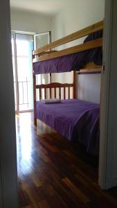 Un dormitorio con una litera con sábanas moradas en Apartamento Los Colonia, en Burgos