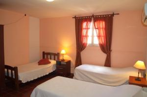 1 Schlafzimmer mit 2 Betten und einem Fenster in der Unterkunft Rutas Hotel in Salta