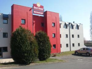 un edificio rojo con un cartel en el costado en BRIT Hotel - Montsoult La Croix Verte, en Baillet-en-France