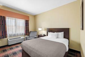 a hotel room with a bed and a chair at Quality Inn & Suites Des Moines Airport in Des Moines +30 photos