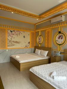 Khách sạn Phúc Đạt - Rạch Giá Phúc Đạt Hotel في Ấp Rạch Mẹo: غرفة نوم بسريرين وساعات على الحائط