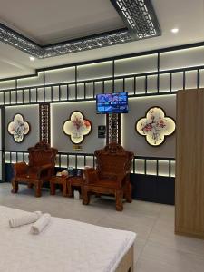 Khách sạn Phúc Đạt - Rạch Giá Phúc Đạt Hotel في Ấp Rạch Mẹo: غرفة بها ثلاثة كراسي وتلفزيون على الحائط +20 صورة