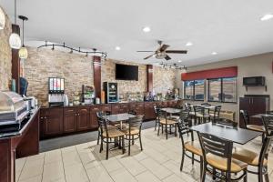 a restaurant with tables and chairs and a bar at Quality Inn & Suites Des Moines Airport in Des Moines