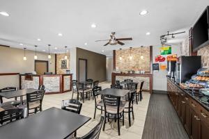 a dining room with tables and chairs in a restaurant at Quality Inn & Suites Des Moines Airport in Des Moines