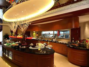 a restaurant with a buffet line with food at Grand Mercure Teda Dalian in Dalian