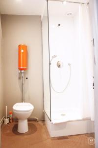 a bathroom with a toilet with a glass shower stall at Hôtel Henri IV in La Rochelle