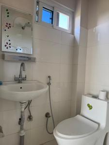 River Tiger Safari & Homestay في Meghauli: حمام مع مرحاض أبيض ومغسلة