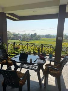 River Tiger Safari & Homestay في Meghauli: فناء مع طاولة وكراسي مع الكمبيوتر المحمول عليه