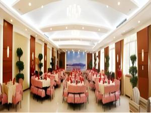 a restaurant with pink tables and chairs in a room at Yichang Three Gorges Project Hotel in Yichang