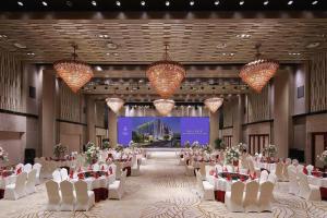 a banquet hall with white tables and chairs and chandeliers at Nanjing Lakehome Hotels and Resorts in Jiangning +248 photos