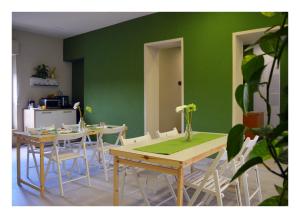 a dining room with two tables and a green wall at B&B Stazione Dittaino in Assoro
