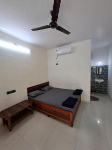 um quarto com uma cama e um ventilador de teto em Madhuban Cottage Varsoli- Alibag em Alibag