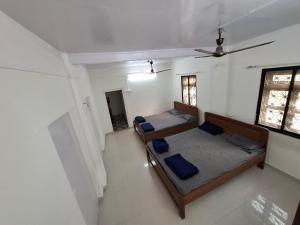 um quarto com duas camas e uma janela em Madhuban Cottage Varsoli- Alibag em Alibag