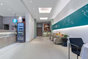 Jinjiang Inn Wenzhou Shuangyu The Terminal في Jiangjunqiao: مطعم فيه بار مع كراسي وكاونتر