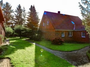 two photographs of a house and a yard at Ferienhaus Wilmshagen in Südhof