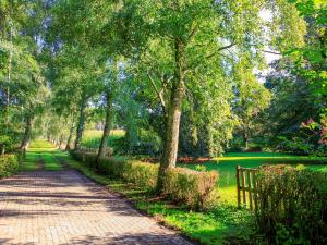 a brick path in a park with trees and a fence at Ferienhaus Wilmshagen in Südhof