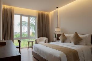 a bedroom with a large bed and a large window at Kaiarasa Villas and Suite in Canggu