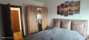 クラグイェヴァツにあるSunshine III Apartmentのベッドルーム1室(ベッド1台、鏡、ドア付)