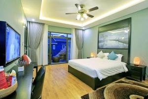 a bedroom with a bed and a ceiling fan at Friendly Villa Hoian in Hoi An