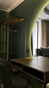 Una sala de estar con una mesa y un espejo. en Котедж Gudz, en Yaremche