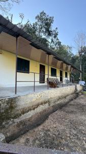 ein gelbes Gebäude mit schwarzem Dach und ein Gebäude in der Unterkunft Nature village resort in Rishikesh