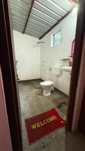 ein Badezimmer mit Toilette und Willkommensschild in der Unterkunft Nature village resort in Rishikesh