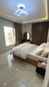 a bedroom with a large bed with a ceiling at Doki sky suite in Cairo