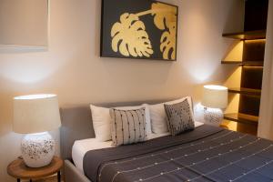 a bedroom with a bed with pillows and two lamps at Peregrina Tulum 202C 1 Bedroom Condo in Tulum +34 photos