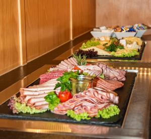 a buffet with several different types of meats and vegetables at Hotel-Restaurant Gasthaus Bonimeier in Niedergottsau