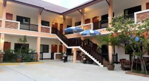 a building with stairs and umbrellas in the courtyard at N-Joy Place in Surin