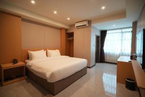 Ένα ή περισσότερα κρεβάτια σε δωμάτιο στο VELIN Pattaya Hotel