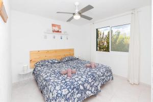 une chambre avec un lit et un ventilateur de plafond dans l'établissement Tranquilo apto con preciosa cala, à Cala en Forcat