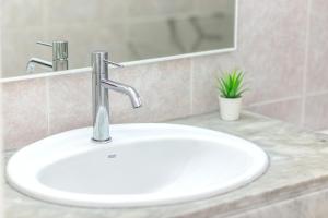 un lavabo blanc dans une salle de bain avec un miroir dans l'établissement Tranquilo apto con preciosa cala, à Cala en Forcat 21 autres photos