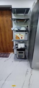 a kitchen with an open refrigerator with food on shelves at Gangi Kota Penthouse in Kovvūr +97 photos