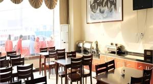 a dining room with tables and chairs in a restaurant at GreenTree Inn Jinan Bus Terminal in Jinan