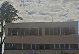 a building with a palm tree in front of it at Ariosa Apartments in Mtwapa
