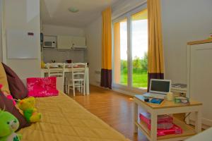 a living room with a bed and a table with a laptop at Résidence Goélia Les Portes d'Honfleur in Boulleville