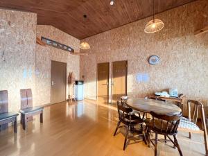 een eetkamer met een houten tafel en stoelen bij Natsumi no Sato in Biei