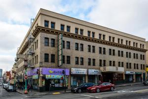 SW Hotel في سان فرانسيسكو: مبنى على شارع المدينة مع سيارات متوقفة في الأمام