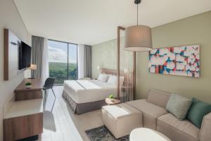 a hotel room with a bed and a couch at Hyatt Place Cancun Airport in Cancún