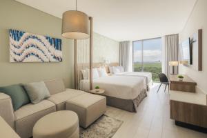 a hotel room with a bed and a couch at Hyatt Place Cancun Airport in Cancún +40 photos