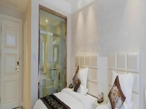 a bedroom with a white bed and a glass door at Changshu Please Hotel in Changshu