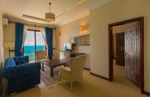 - un salon avec un canapé bleu et une table dans l'établissement Golden Tulip Zanzibar Resort, à Zanzibar City