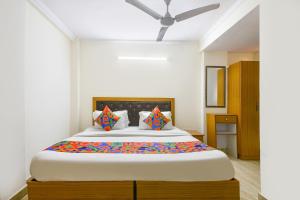 Un dormitorio con una cama grande con almohadas de colores. en FabHotel The Rivlet Centre, en Nueva Delhi