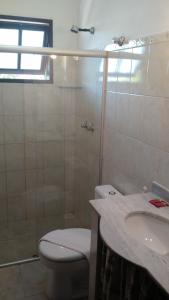 a bathroom with a toilet and a shower and a sink at Pousada Mar e Marés in Rio das Ostras