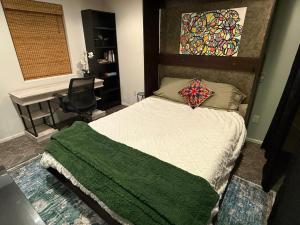 Un dormitorio con una cama con una manta verde encima. en Sedona Prime Location-walk to trails & shopping, en Sedona