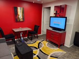 sala de estar con TV y pared roja en Sedona Prime Location-walk to trails & shopping, en Sedona