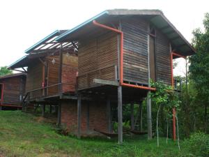 Una casa de madera con un balcón en un lateral. en Paganakan Dii Tropical Retreat, en Sepilok