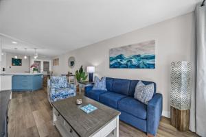 a living room with a blue couch and a table at Hip Oceanfront Resort Vistas in Kihei