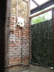 a bathroom with a brick wall with a shower at Paganakan Dii Tropical Retreat in Sepilok